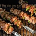 Juicy chicken and vegetable skewers grilling on barbecue grill, perfect for outdoor cooking and BBQ parties, featuring marinated chicken, bell peppers, and onions.