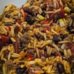 Ground beef and rice skillet with black beans, corn, and diced tomatoes. Hearty and flavorful comfort food dish perfect for any meal.